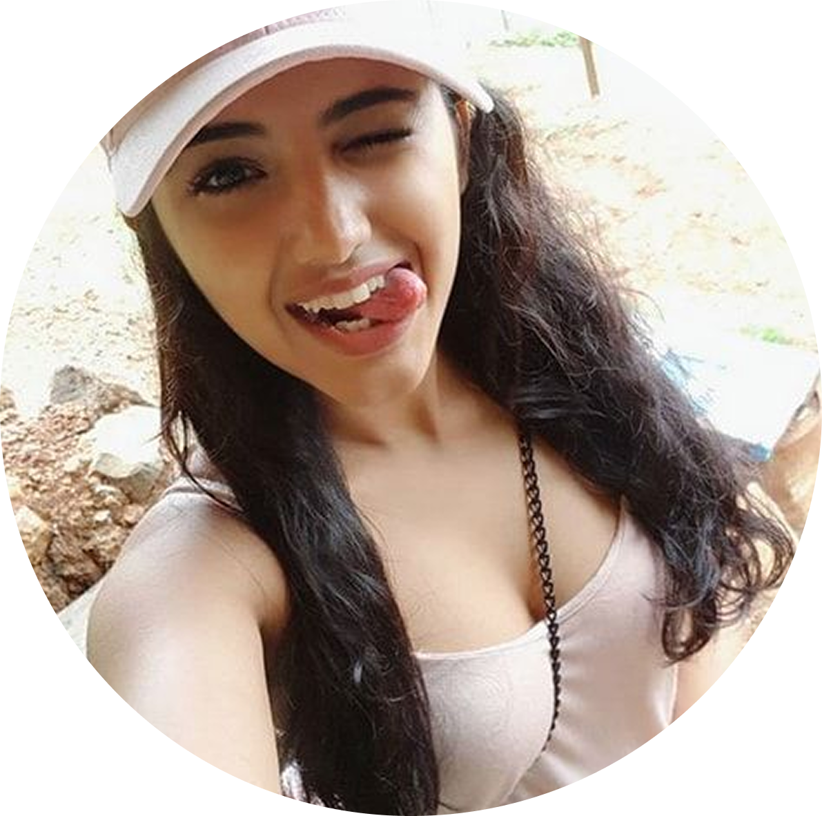 Woman wearing a white visor and pink top outdoors