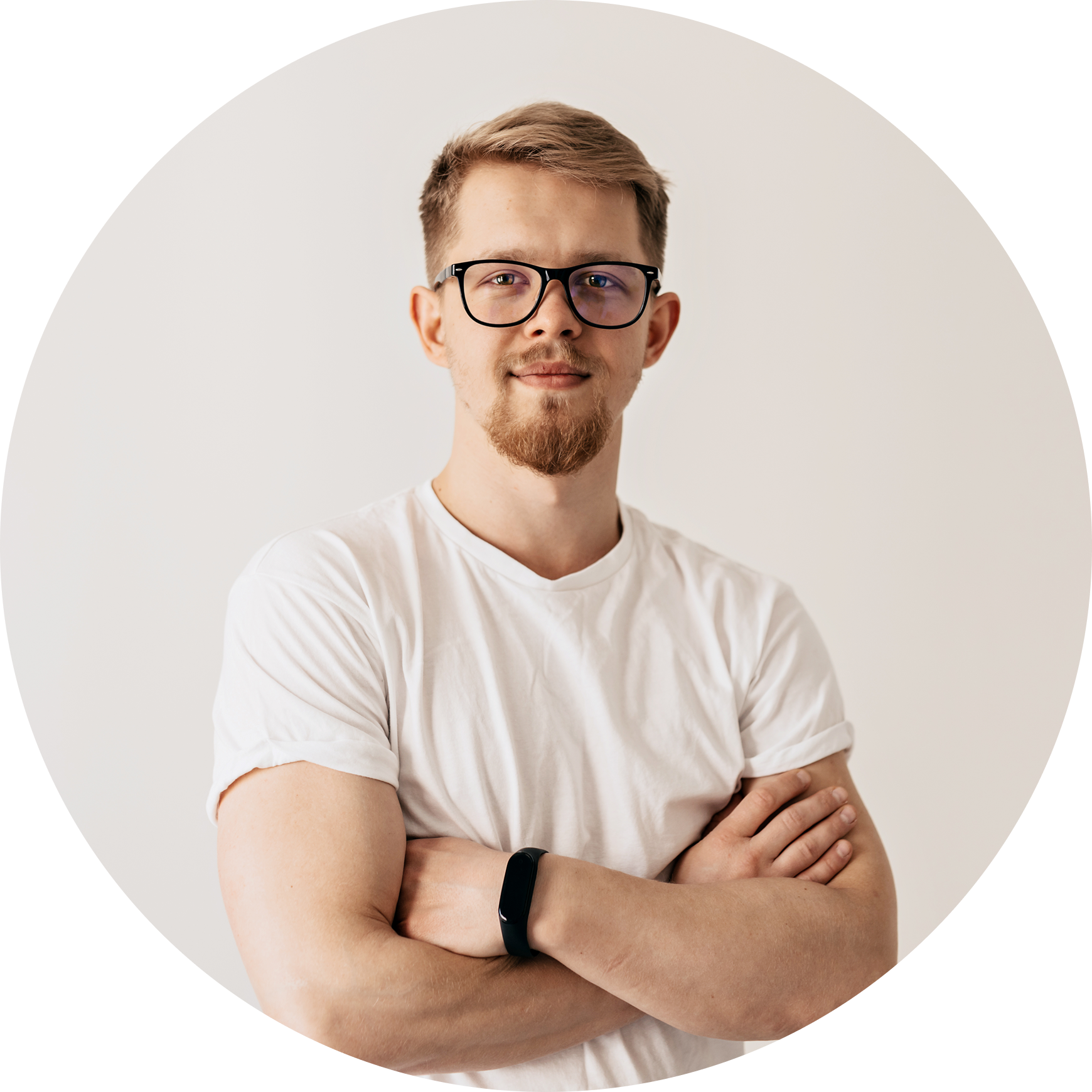 Man wearing glasses and a white t-shirt with arms crossed on a plain background